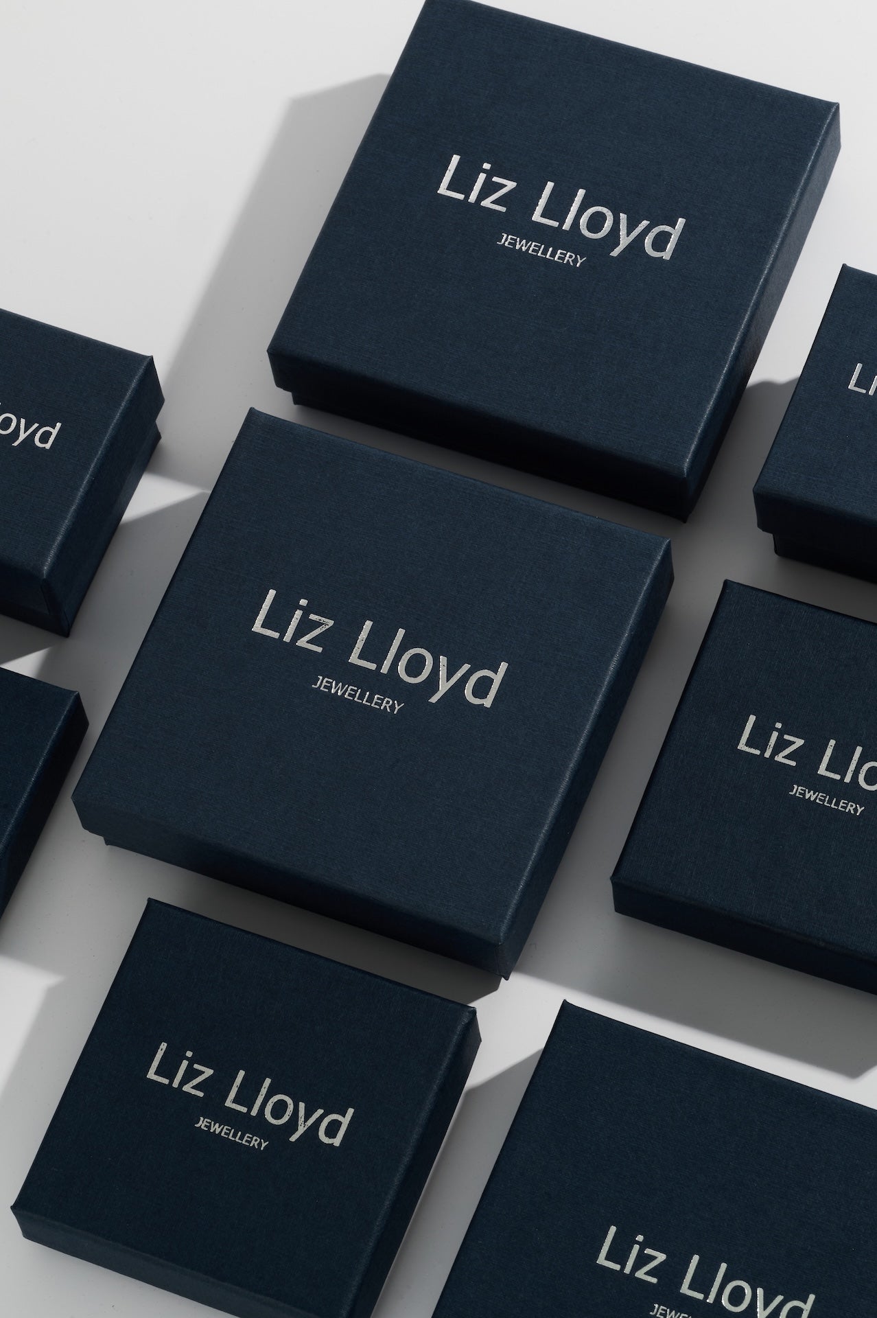 Dark blue jewellery boxes with Liz Lloyd Jewellery written in silver lettering