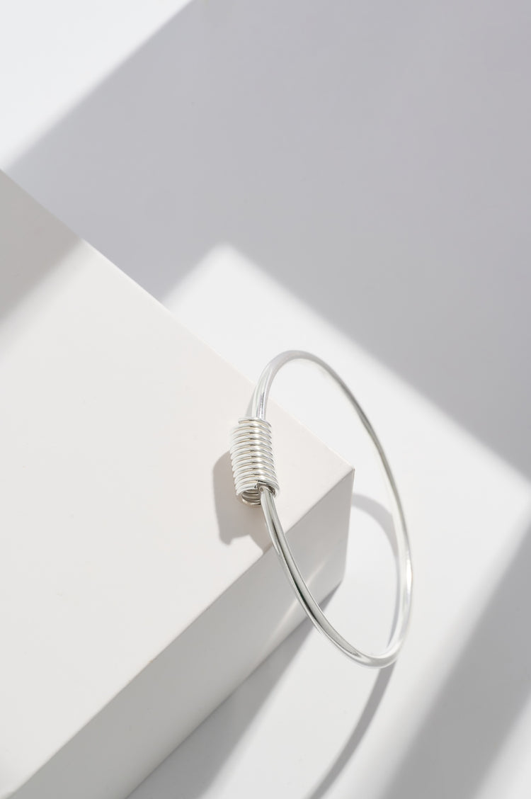 Sterling silver coil bangle made from 3mm wide silver wire with the coil measuring 16mm long and 8mm wide 