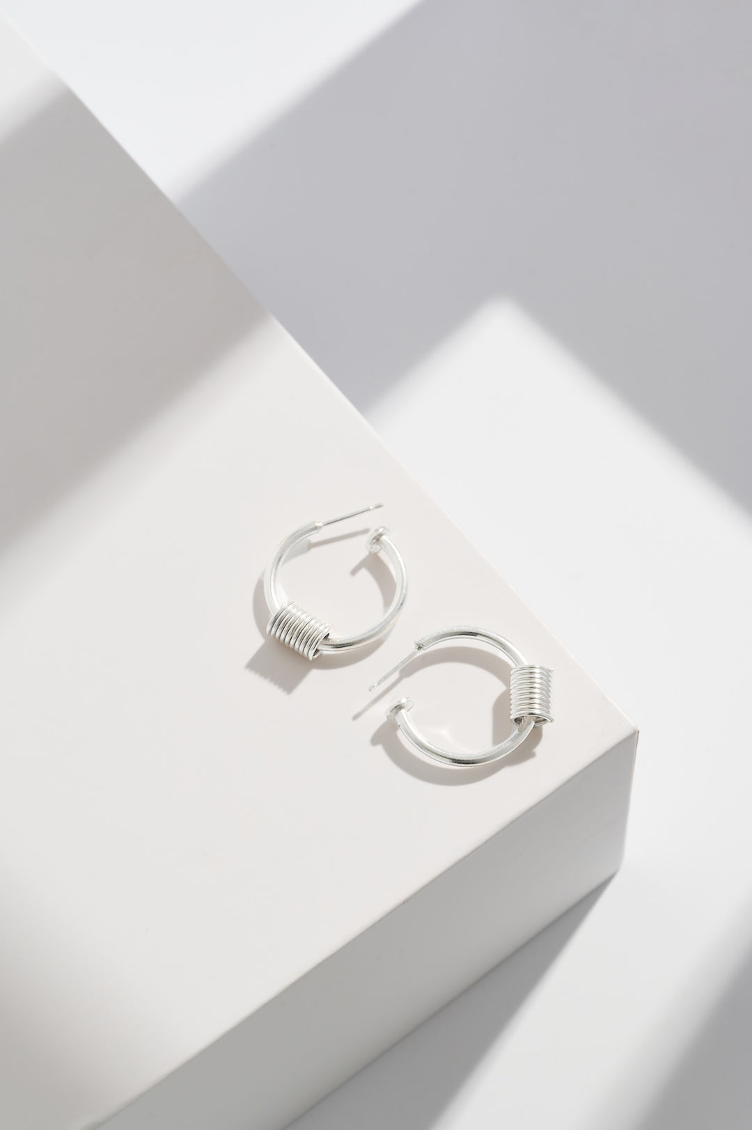 Sterling silver hoops with sterling silver coils and sterling silver disc at end of the hoops