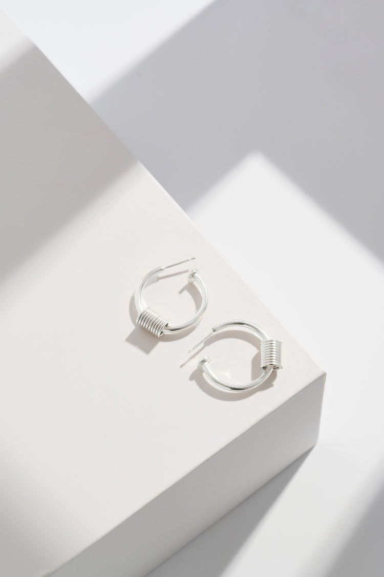 Sterling silver hoops with sterling silver coils and sterling silver disc at end of the hoops