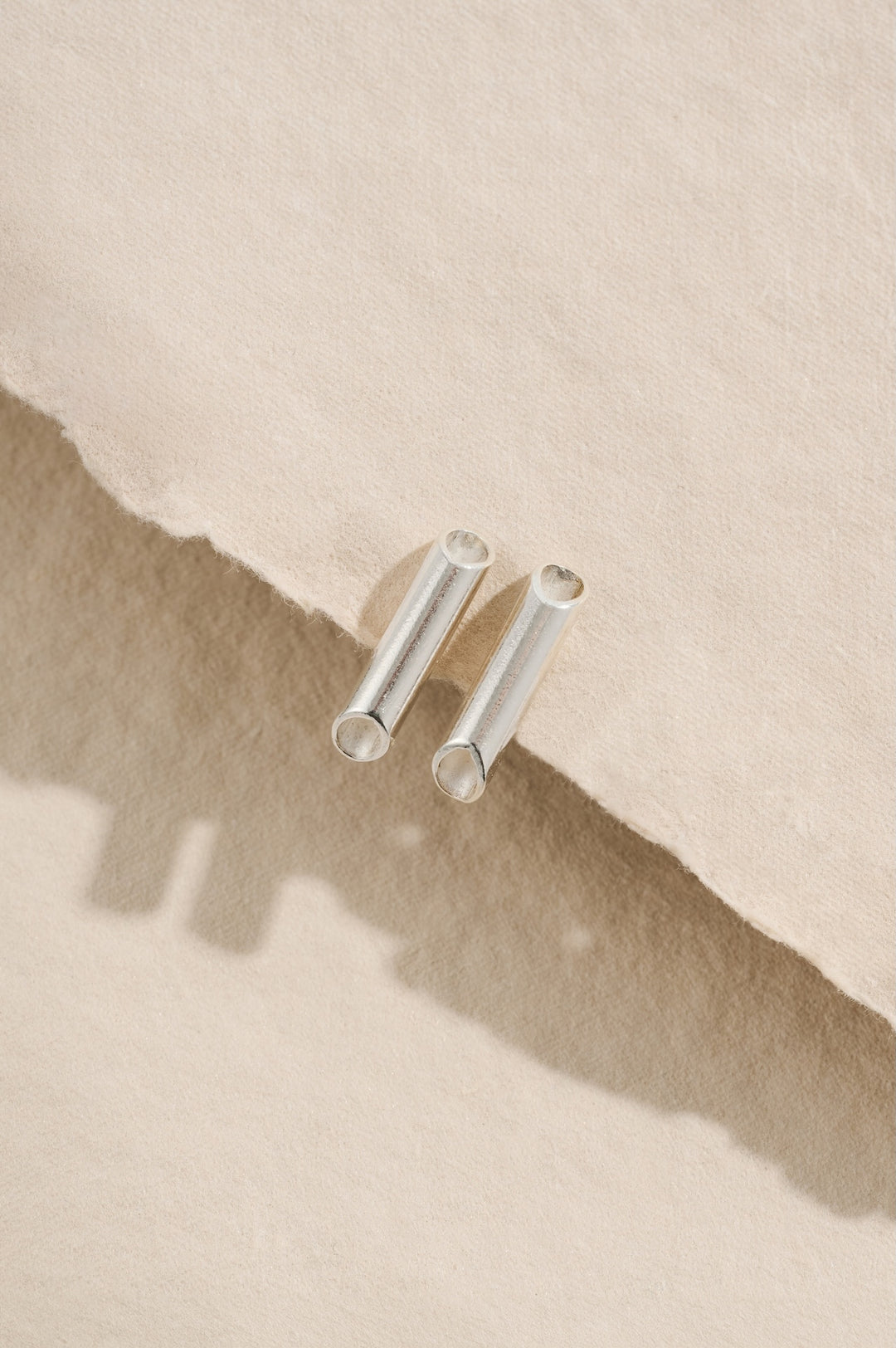 Small sterling silver minimalist tube stud earrings 14mm in length with diagonally tapering ends