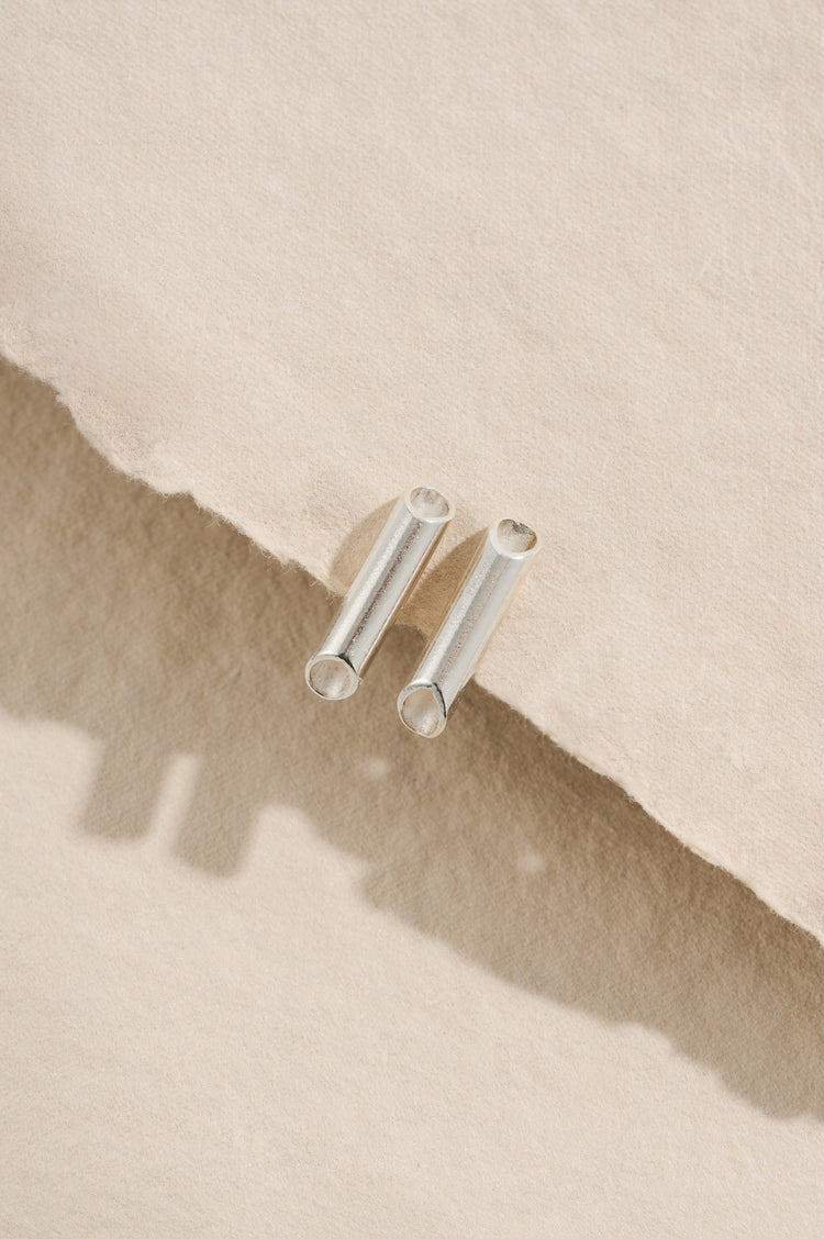 Small sterling silver minimalist tube stud earrings 14mm in length with diagonally tapering ends